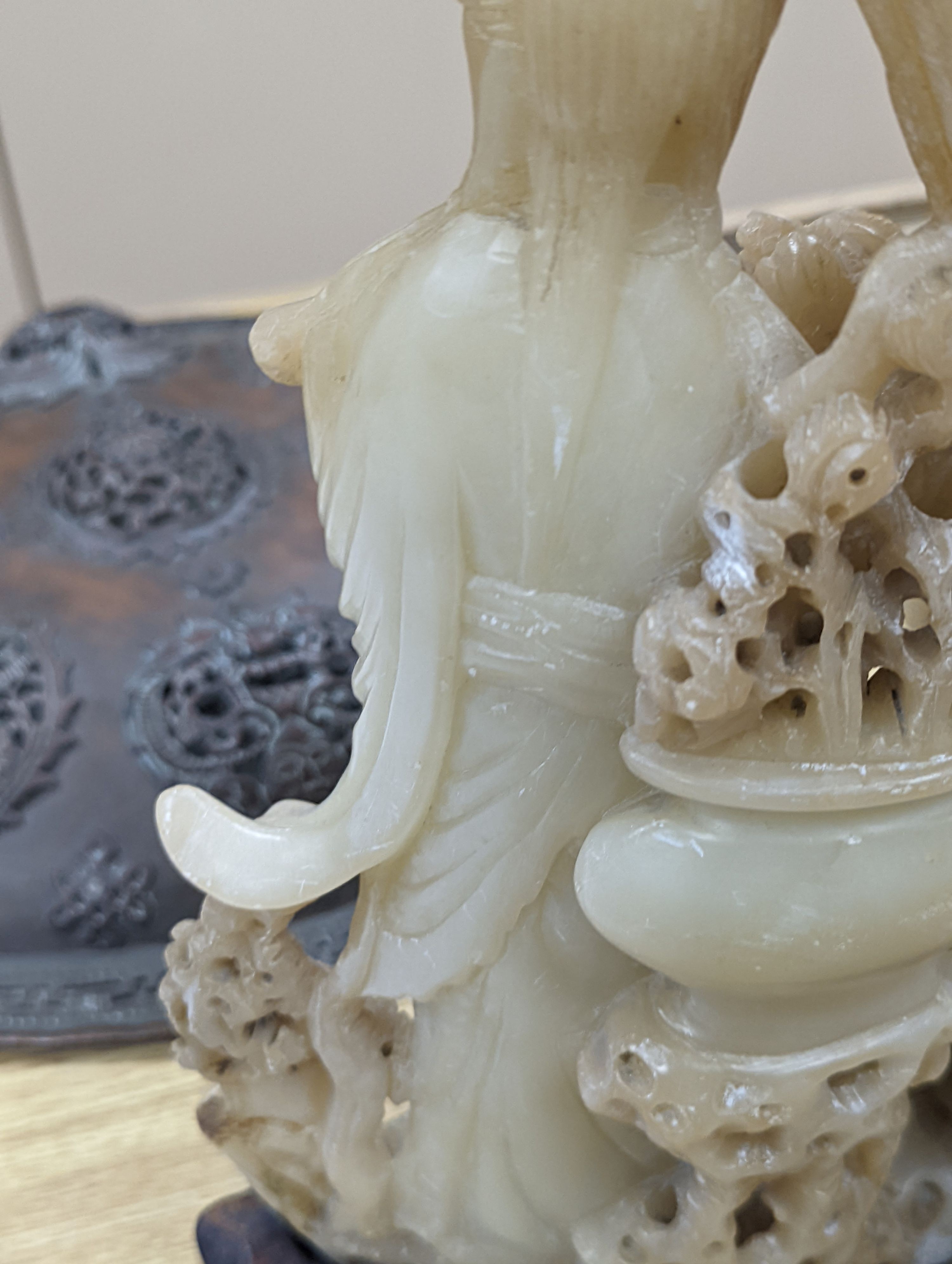 A Chinese soapstone carving of two ladies, wood stand, early 20th century, 36 cms high.